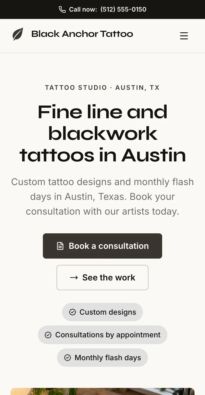 The Black Anchor Tattoo website on a phone